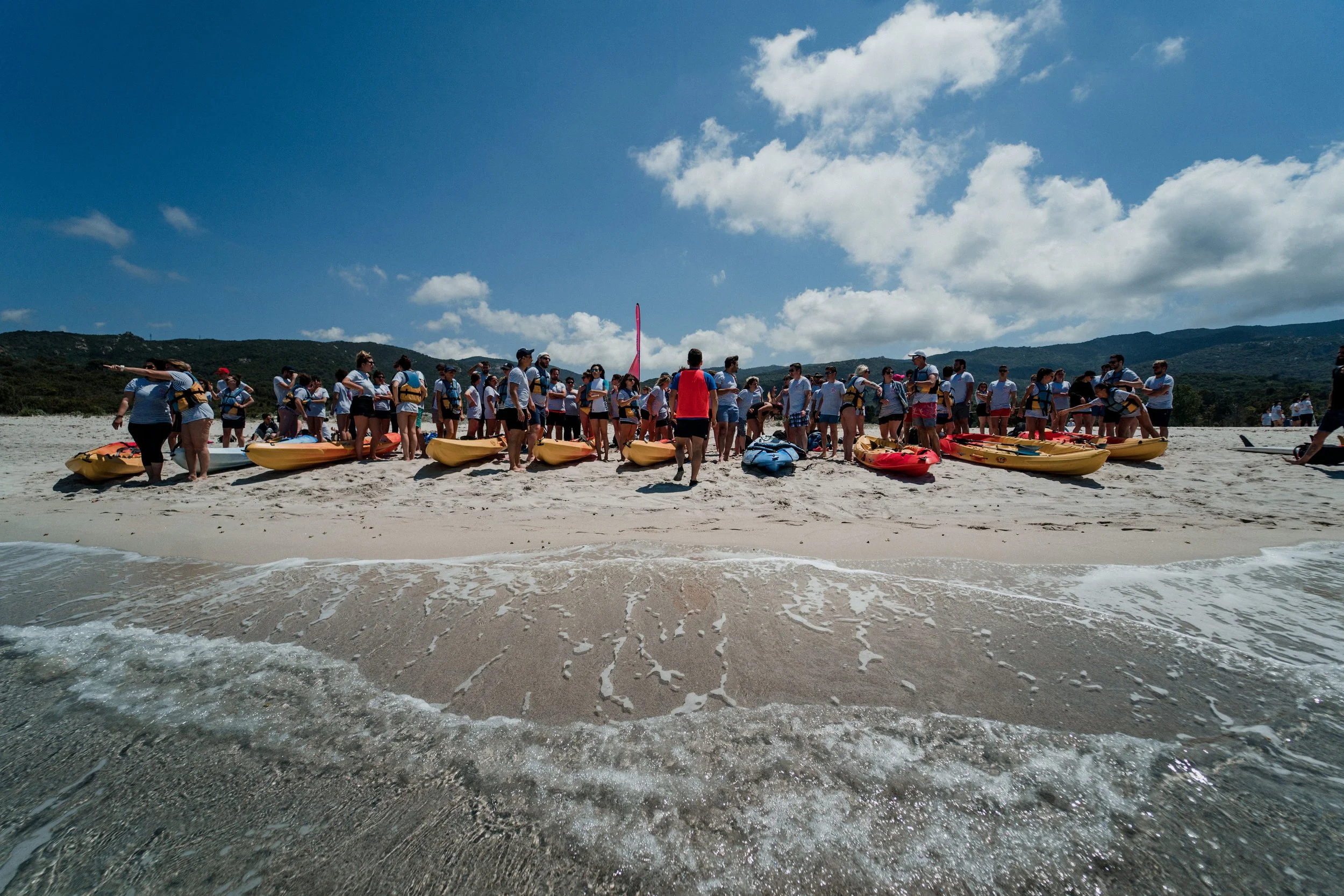 Séminaire de AYLO : un groupe d’entreprise à la plage avec des kayaks, préparé pour une activité de team-building.