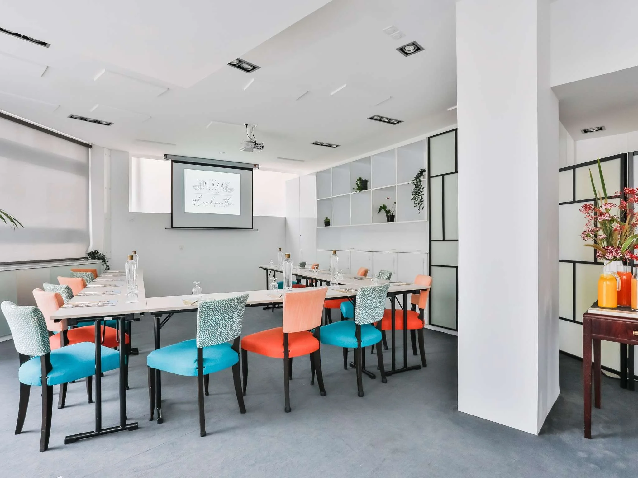 Salle de réunion à l’hôtel Mercure Plaza avec un design fonctionnel et des chaises colorées. L’espace est idéal pour accueillir de petits séminaires et événements d’entreprise.