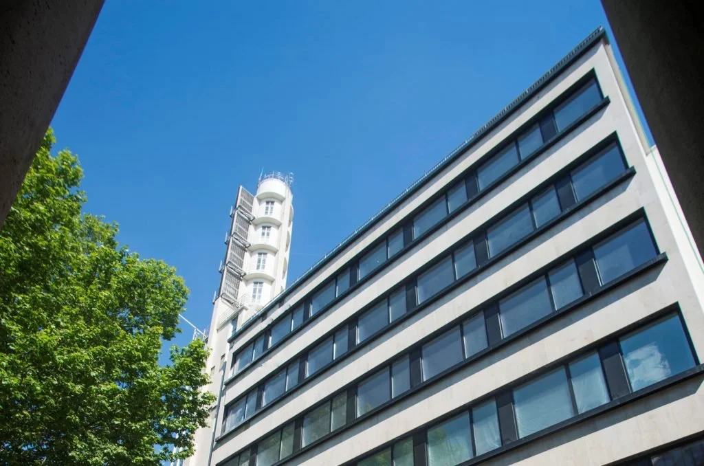 Façade extérieure de l’hôtel Mama Shelter Bordeaux, un bâtiment moderne avec un design de fenêtres empilées et une tour Art déco au sommet.