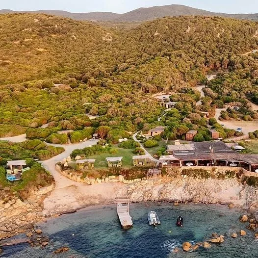 Vue aérienne du Domaine Saparella en Corse, une propriété sur une côte rocheuse avec plage et quai, idéale pour des séminaires d’entreprise