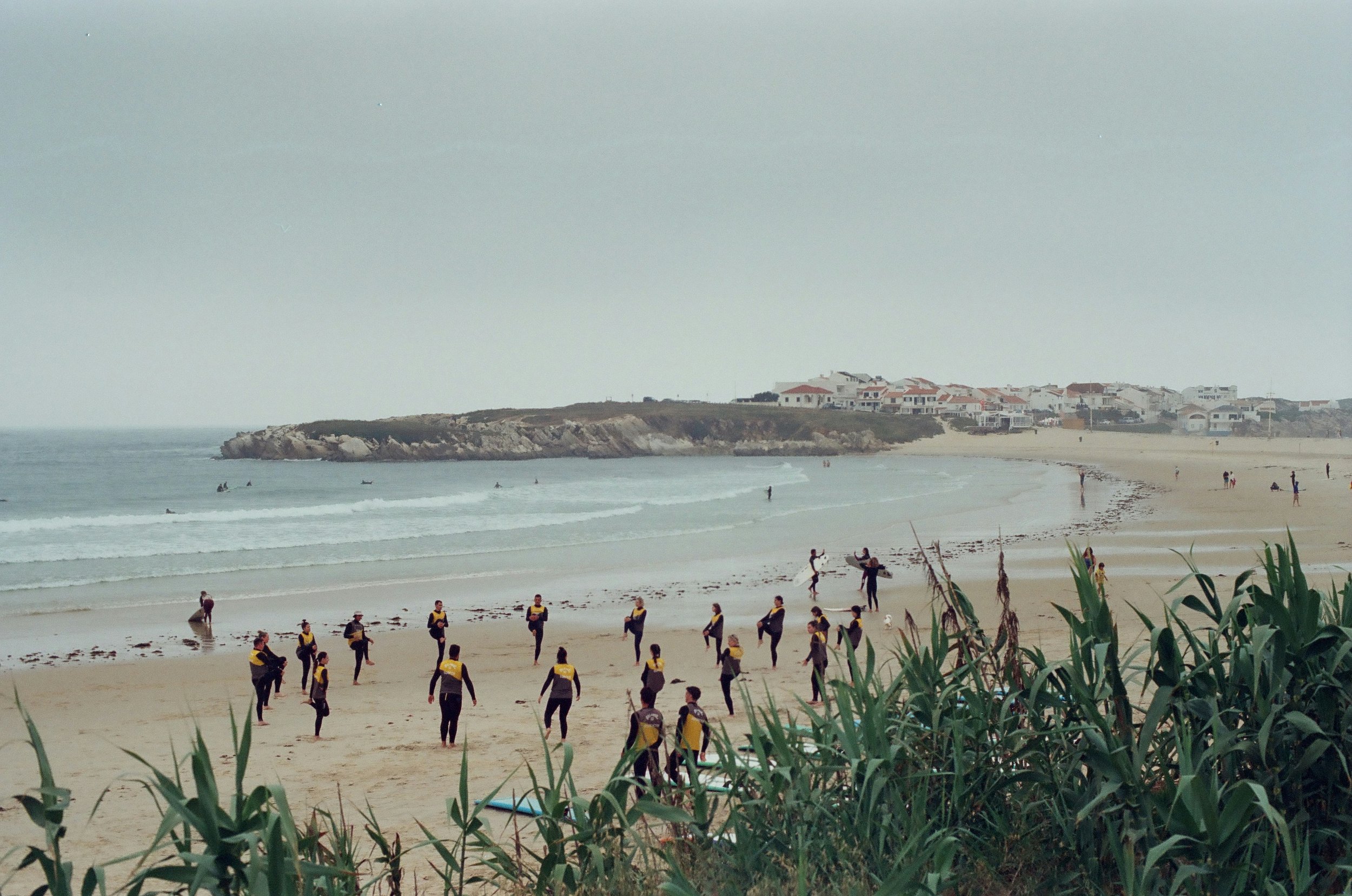 Événement AYLO sur la plage : un groupe d’entreprises se réchauffant avant une activité aquatique.