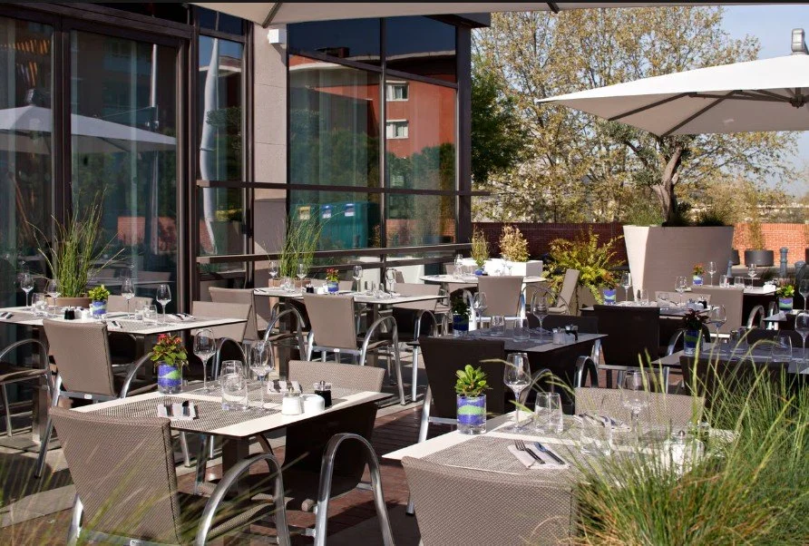 Terrasse et restaurant extérieur de l’Hôtel Renaissance Aix-en-en-Provence, idéal pour les dîners de groupe et les événements sociaux.