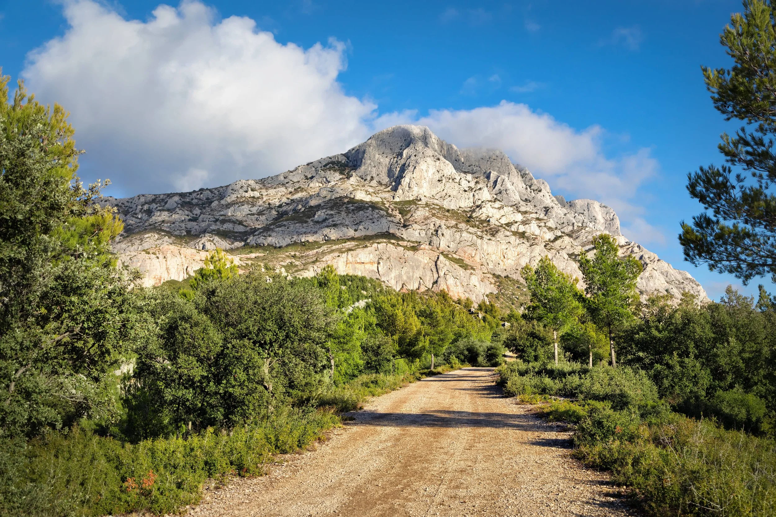 Un chemin de terre qui mène à une montagne rocheuse, idéal pour les voyages d’aventure et d’exploration.