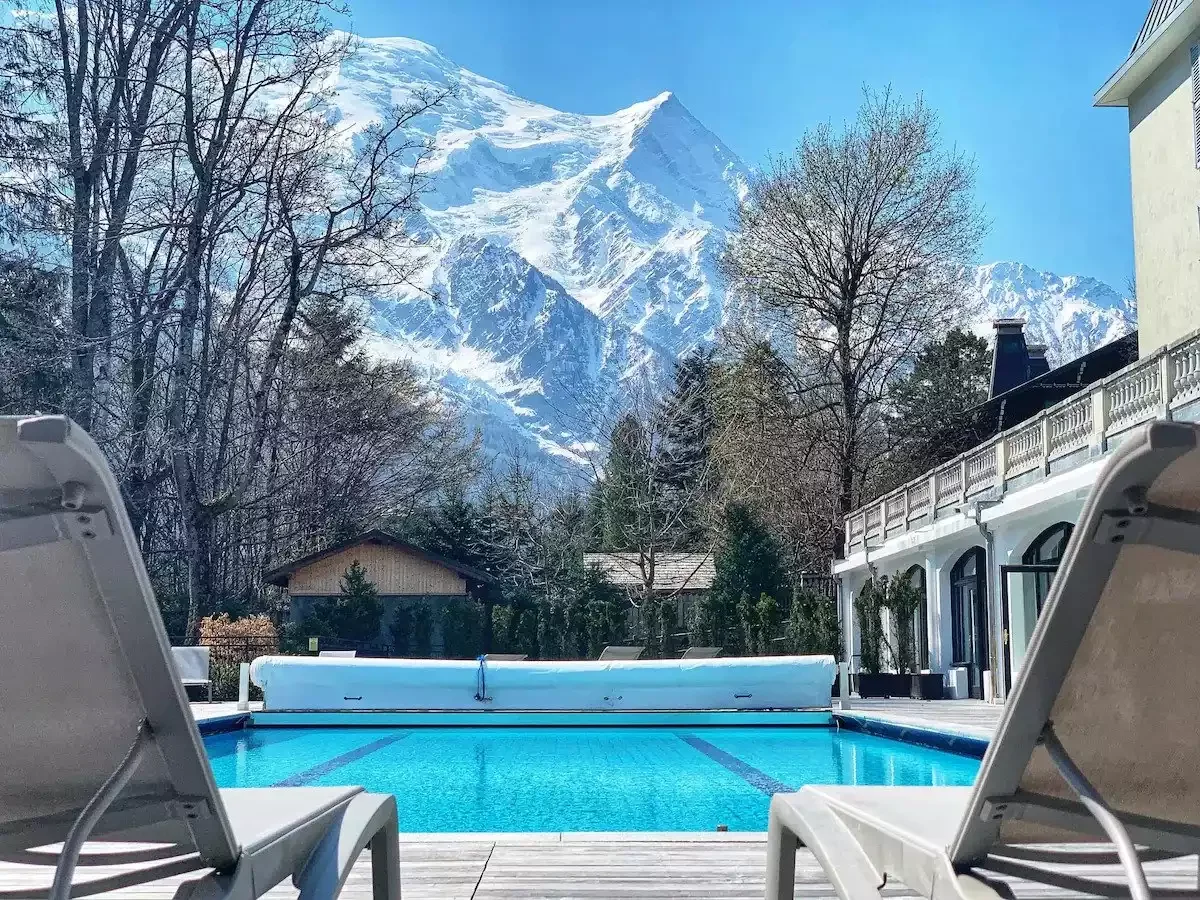 Piscine extérieure de l’Hôtel La Folie Douce 4* avec vue sur les montagnes enneigées. La piscine est couverte, indiquant son utilisation hors saison ou par temps froid.
