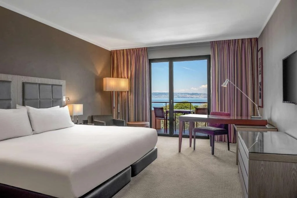 Chambre contemporaine du Hilton Évian-les-Bains – décoration épurée et balcon avec vue sur le Lac Léman – Aylo Montagne