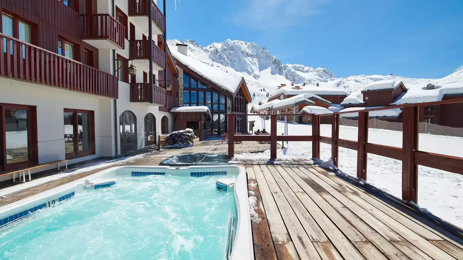 Jacuzzi extérieur de l’hôtel L’Eden des Cimes à La Plagne, avec une terrasse en bois et vue sur la station enneigée. Un espace idéal pour la détente lors des pauses d’un séminaire Aylo Montagne.