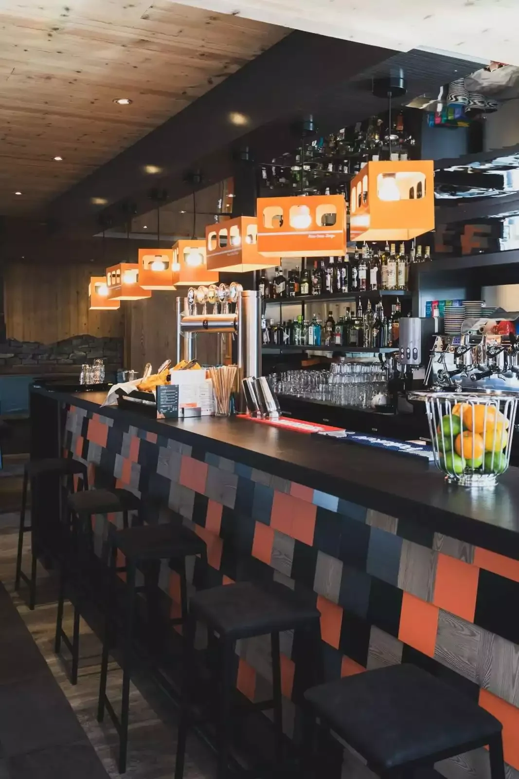 Bar de l’hôtel à la Base Camp Lodge avec un design moderne et un comptoir carrelé. L’ambiance sociale est idéale pour prendre un verre.