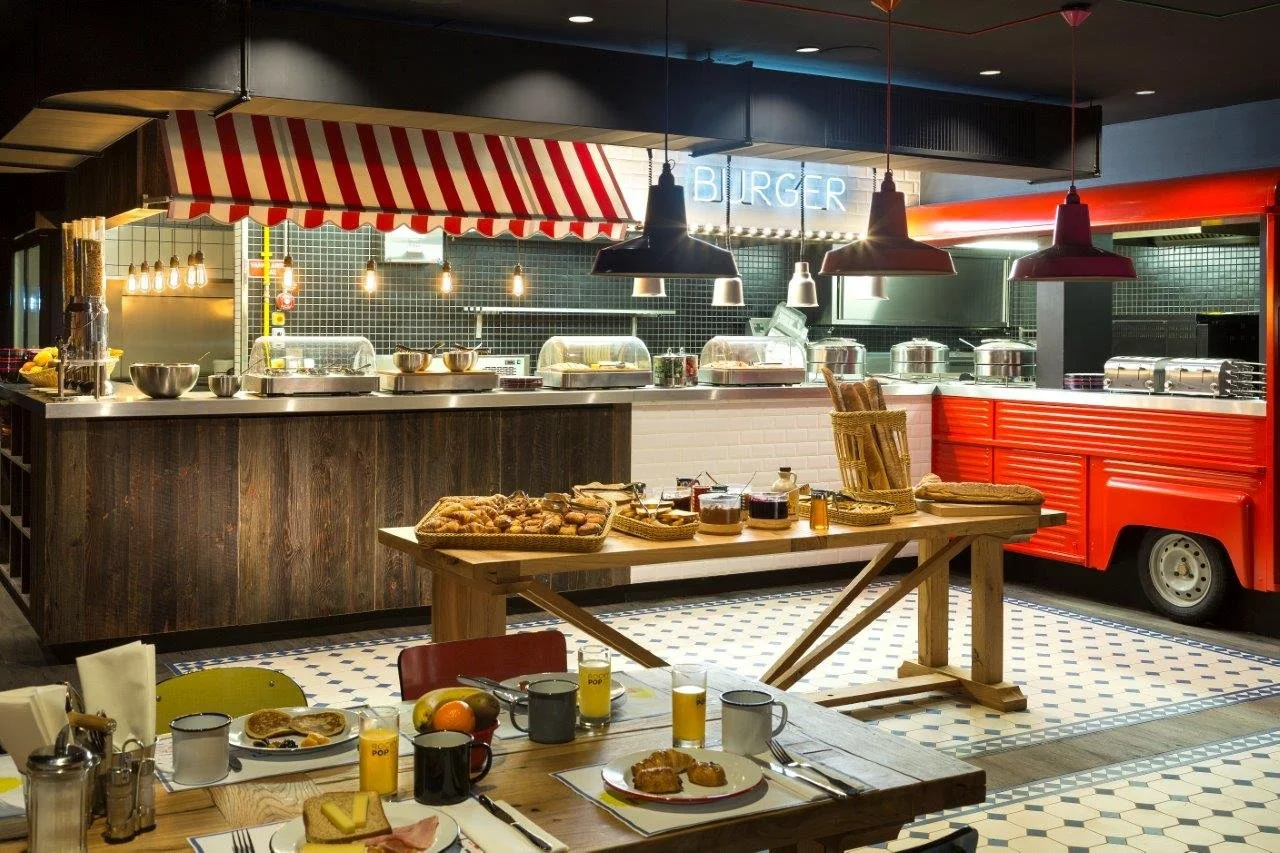 Restaurant du Rocky Pop Hotel avec un design créatif de food truck. Le comptoir est rempli d’options de buffet, offrant une expérience culinaire amusante et unique pour les clients.