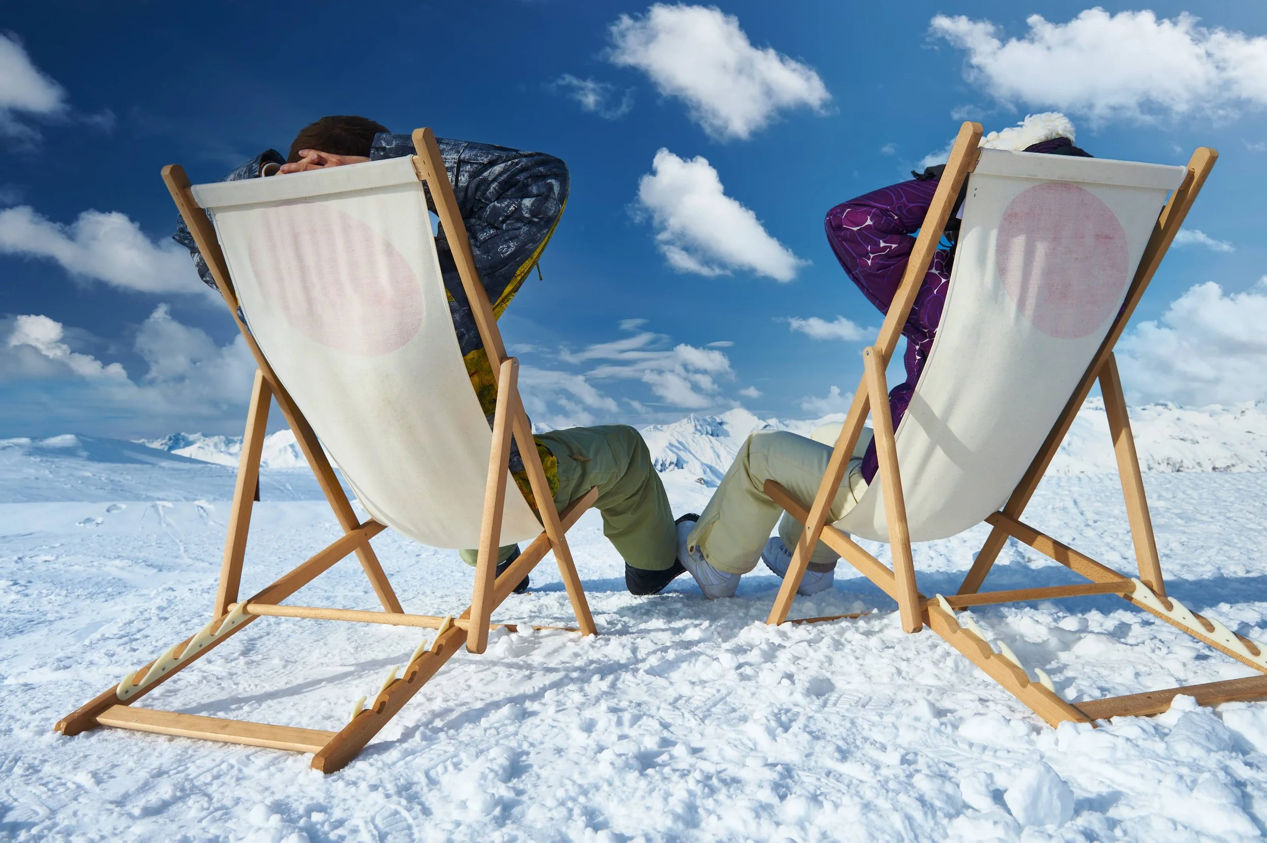 Un participant à un séminaire d’Aylo Montagne se détend dans une chaise de plage sur la neige à Méribel. La personne se repose sous un ciel bleu, avec vue sur les sommets alpins.