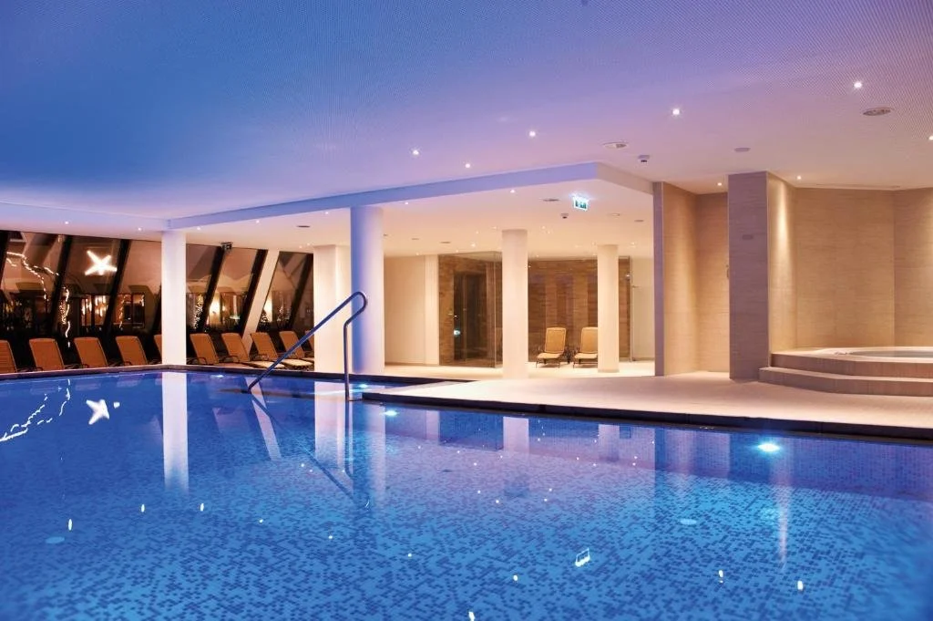 Piscine intérieure de l’Alpenhaus Kaprun avec ambiance zen et espace wellness – Séminaire et détente en Autriche – Aylo Montagne