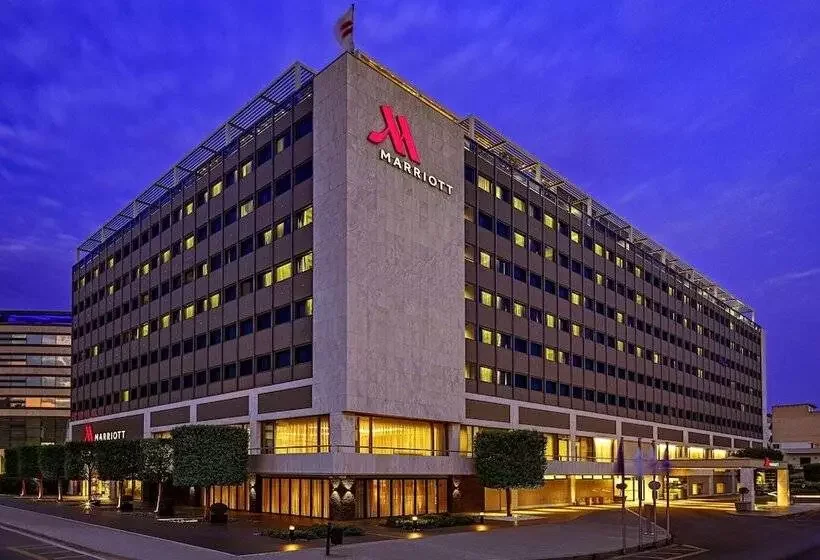 Extérieur nocturne de l’hôtel Marriott à Athènes, un grand hôtel moderne idéal pour les conventions et événements corporatifs.