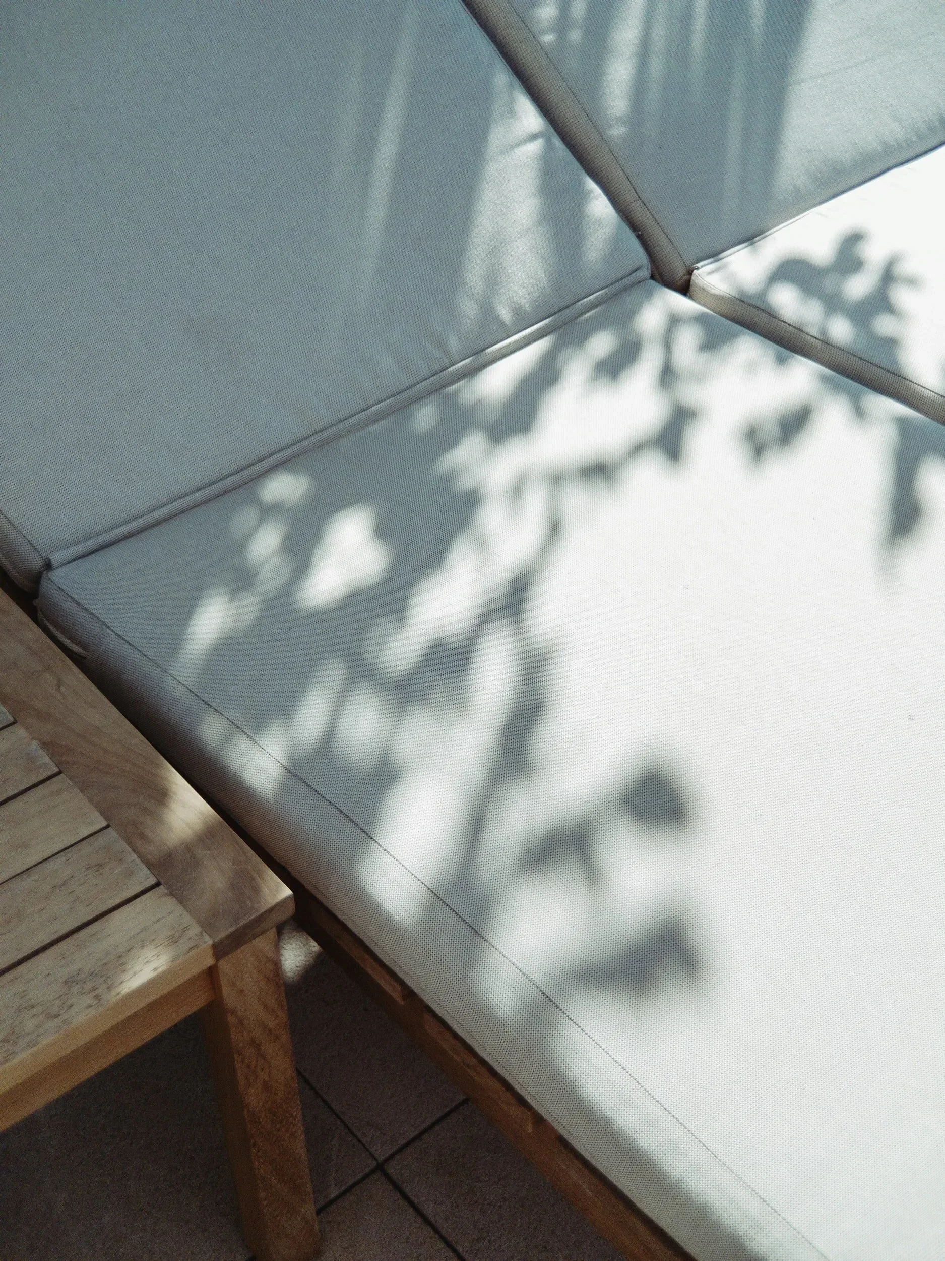 Un transat de détente sur une terrasse, à l’ombre des plantes, qui symbolise la relaxation dans une destination de voyage AYLO.