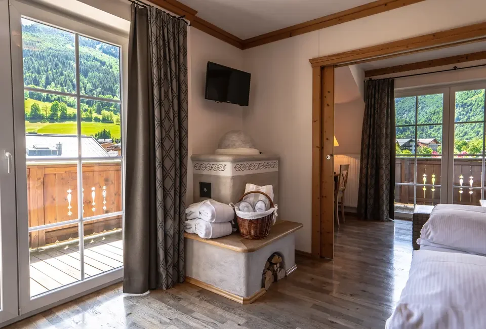Chambre élégante de l’hôtel Kaprunerhof 4* à Kaprun, décoration alpine et confort premium – hébergement haut de gamme pour séminaire Aylo Montagne.