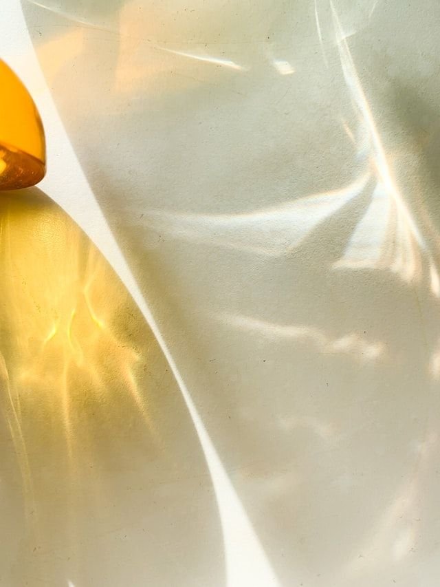 Close-up of a crumpled metallic or reflective foil surface with light reflections and shadows.