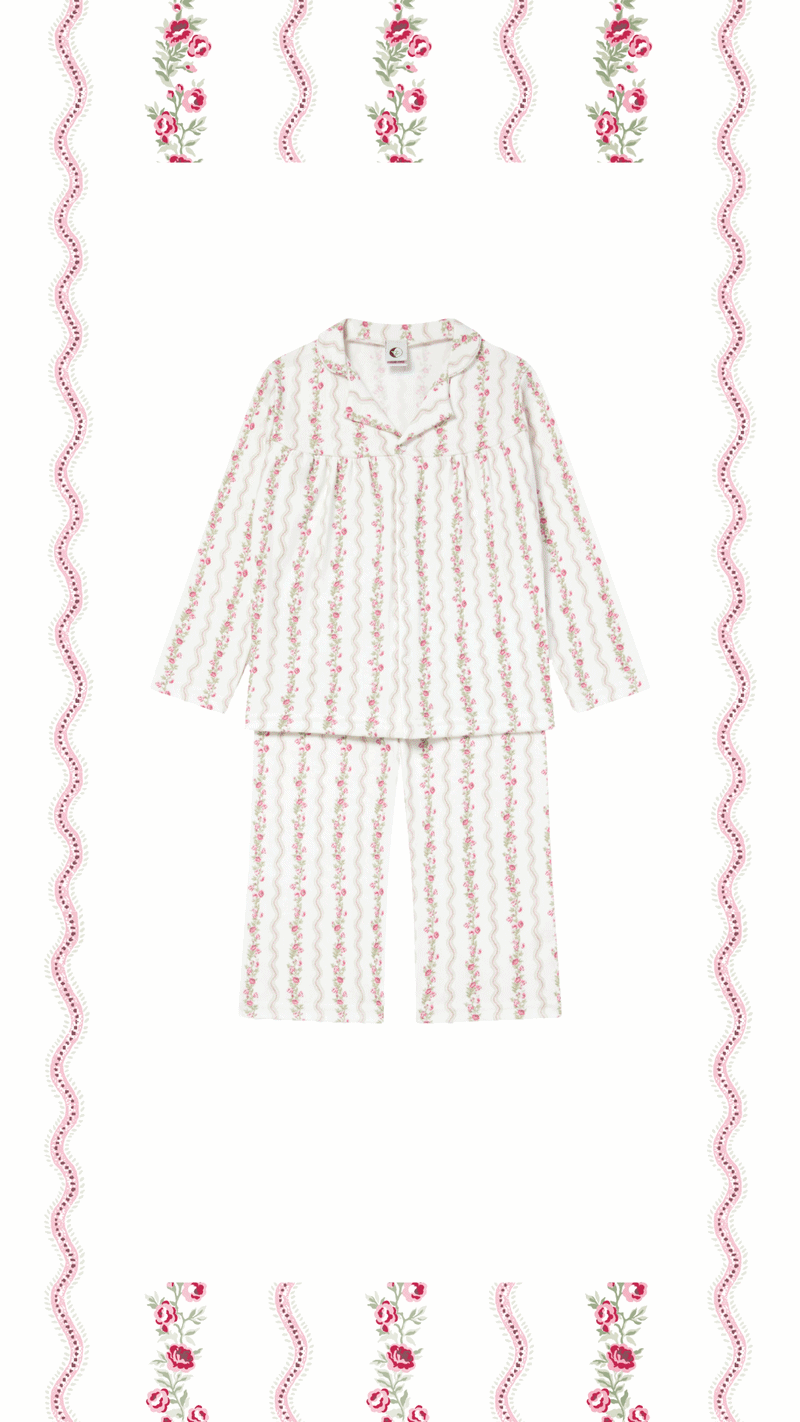 A set of pink and white floral pajamas with a button-up top and matching pants, displayed on a white background with pink and floral patterned border and top.