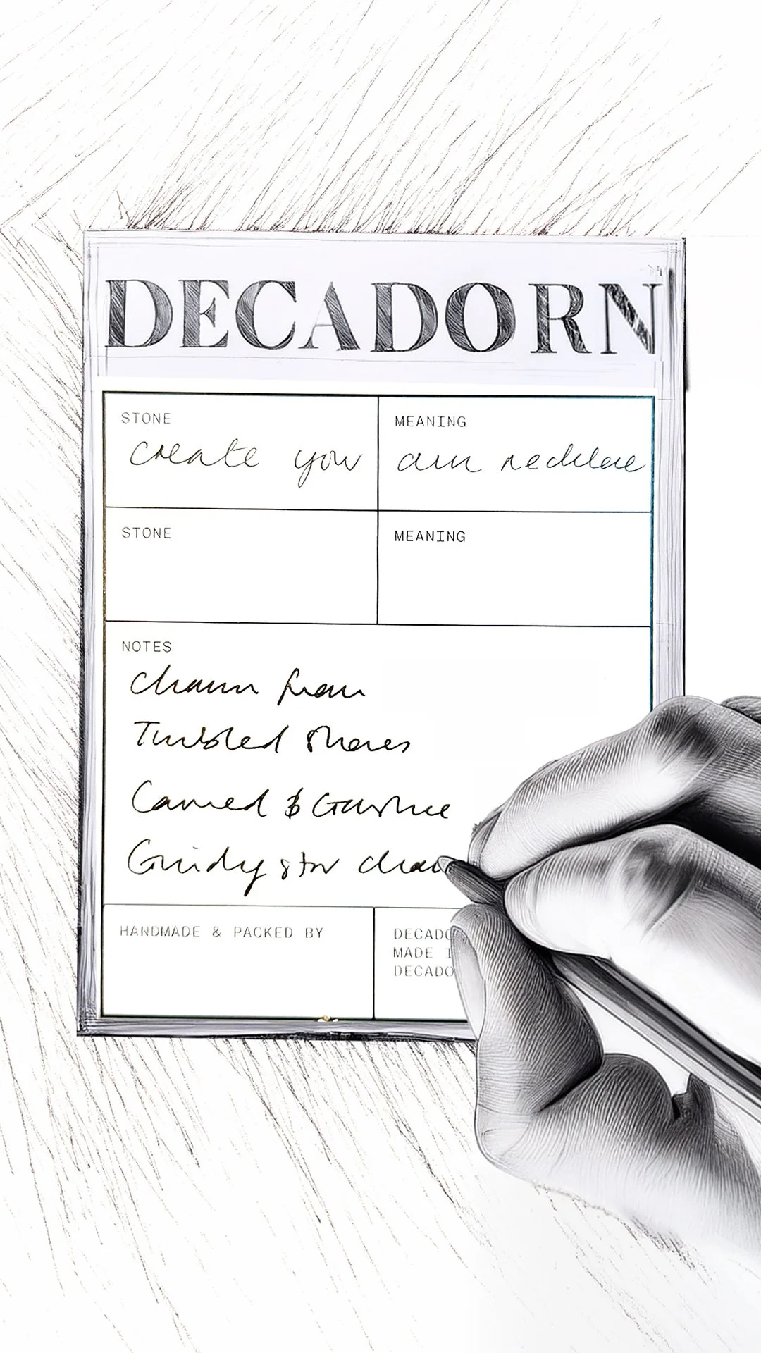 Close-up of a hand writing on a decoupage label with a pen, with handwritten notes about materials and details.