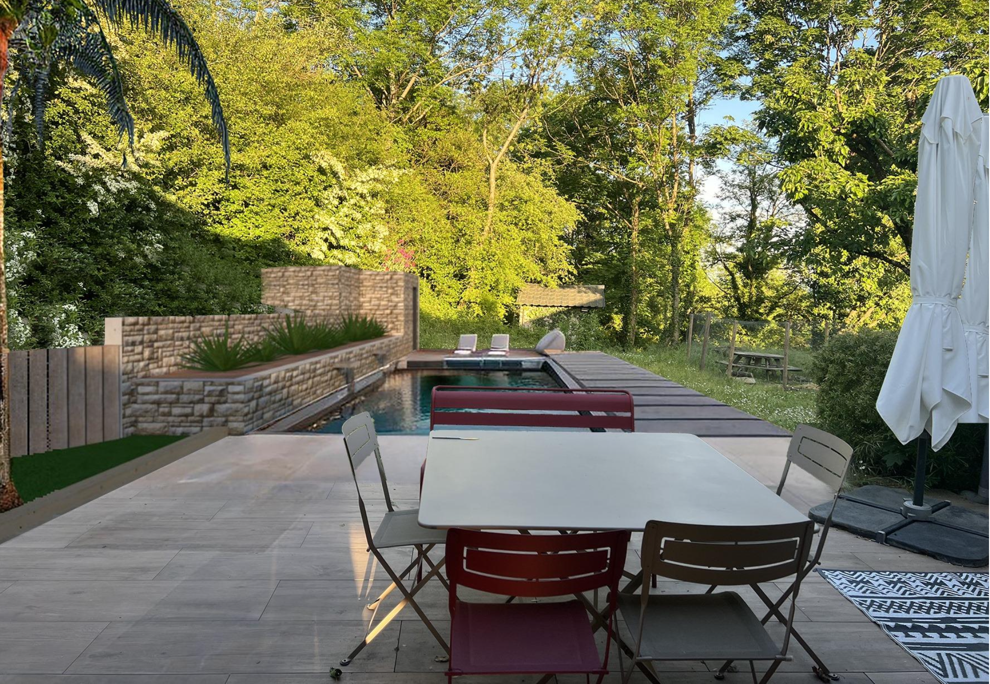 Terrasse avec table, chaises, parasol, piscine entourée de verdure et de arbres.