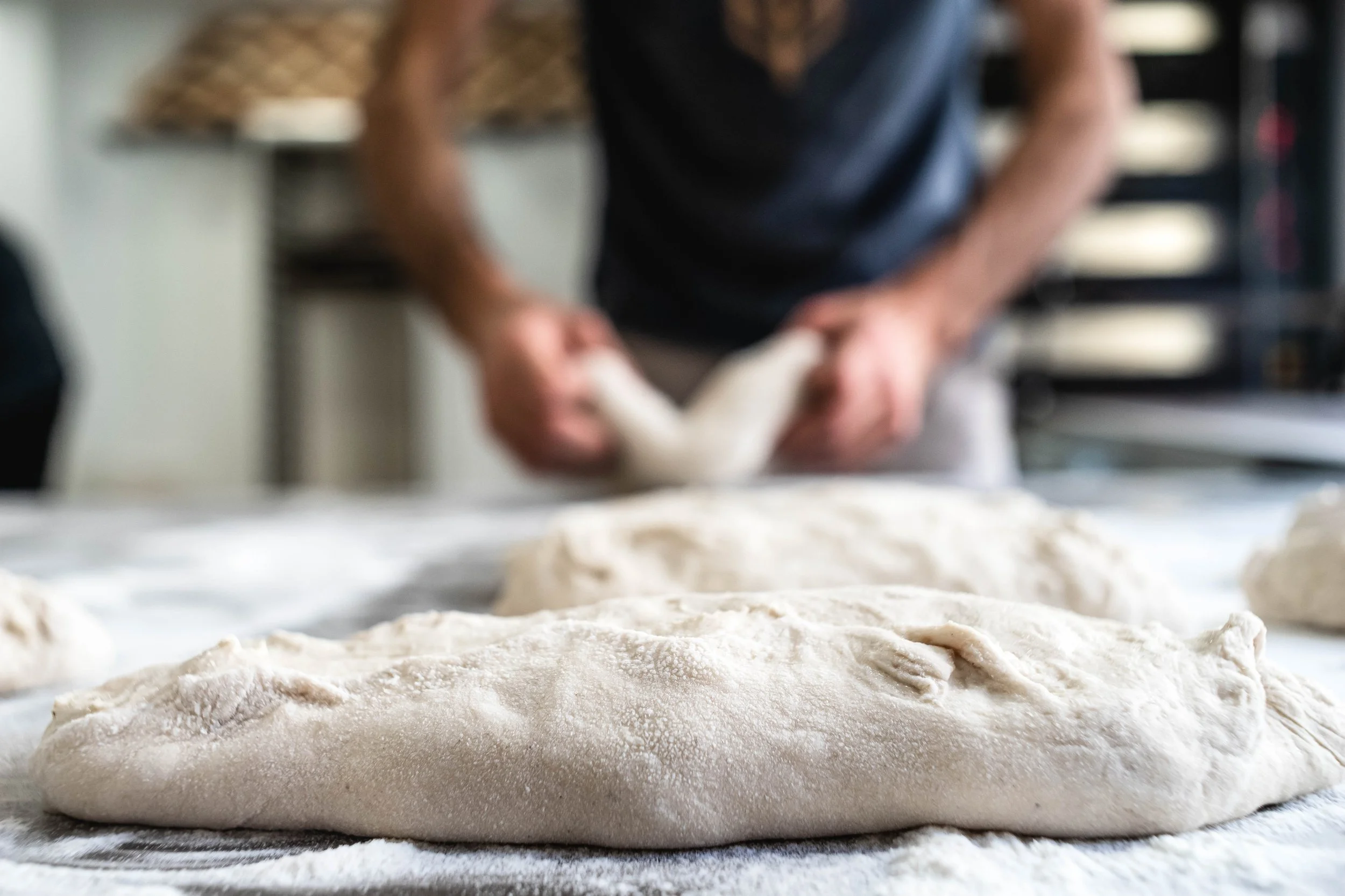 Persona amasando masa en una mesa de cocina
