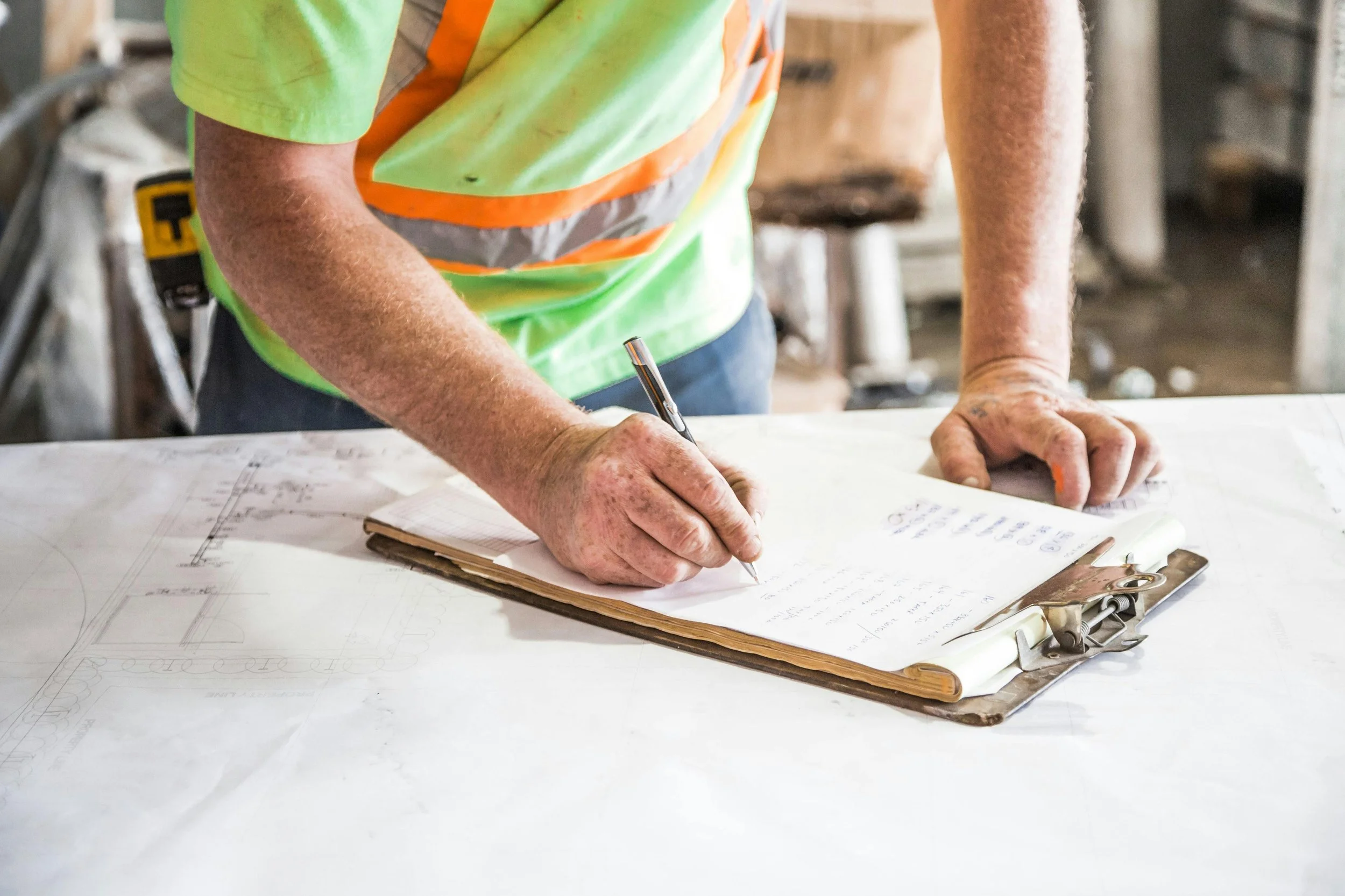 Construction professional reviewing building plans and documentation during a cladding remediation project