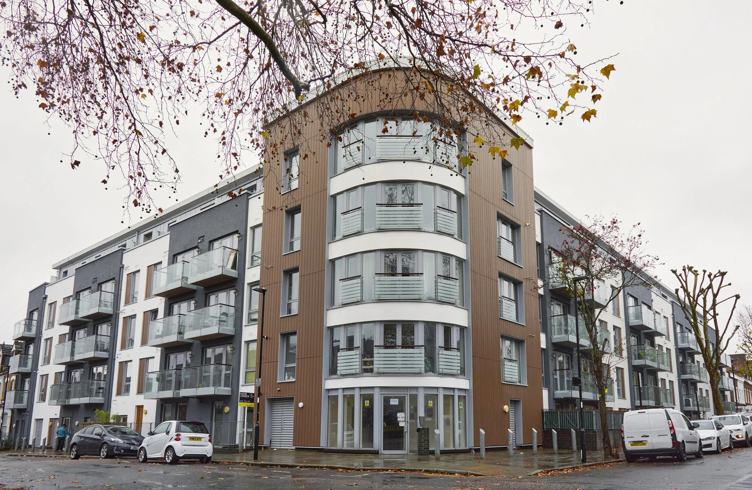 Kinver House, Islington apartment building with curved balconies and a central vertical feature, pictured following cladding remediation works.