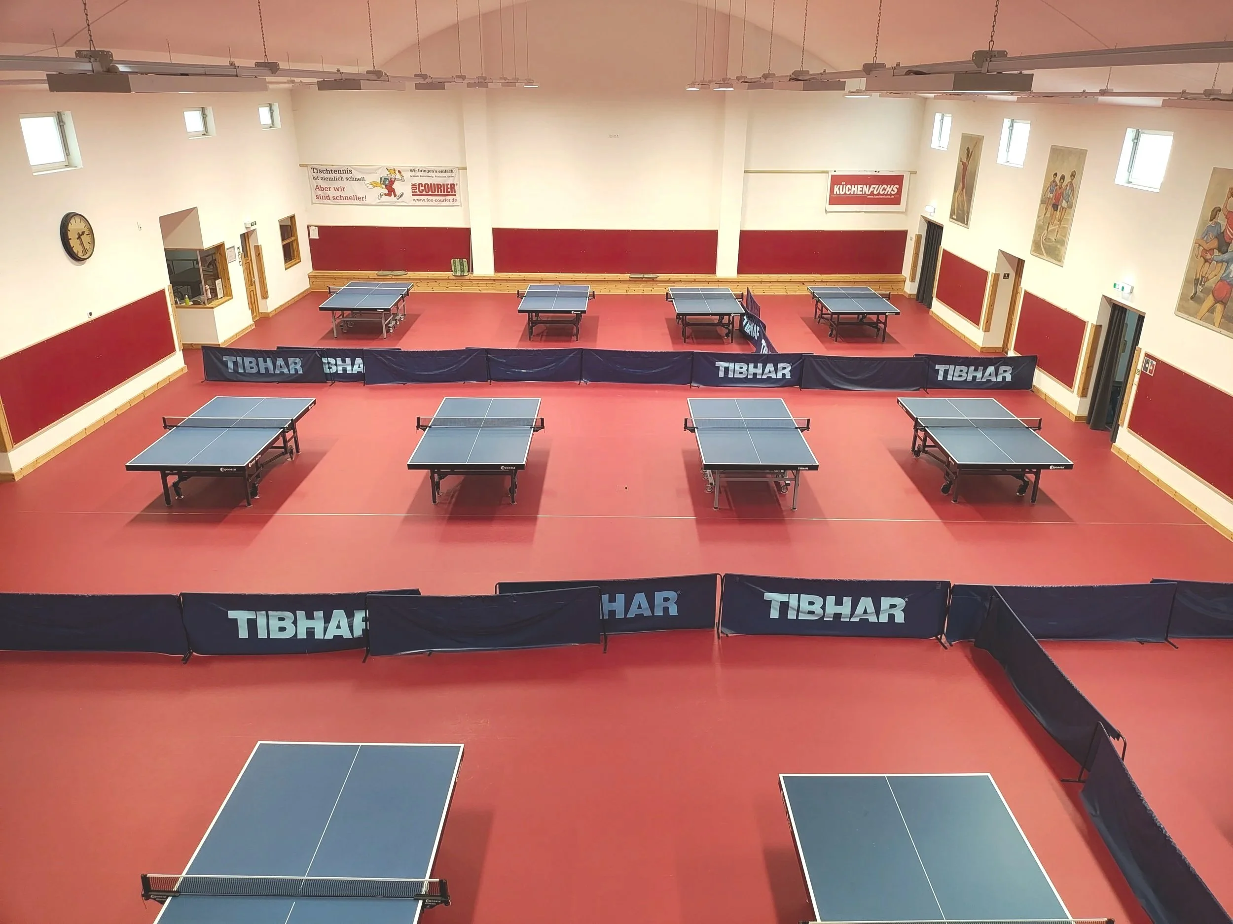 Tischtennishalle mit mehreren Tischtennis-Tischen zu vermieten, inkl. Trainerteam für Lehrgänge buchbar. Trainieren auf rotem Tischtennis Boden möglich. Einzeltraining und Gruppentraining Tischtennis