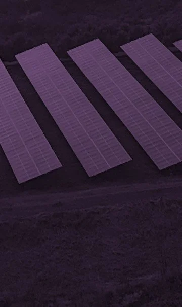 Multiple solar panels in a row in a dark area, possibly used for renewable energy generation.