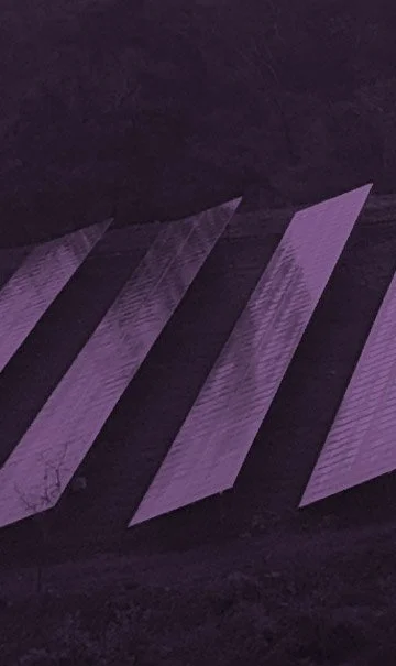 Close-up of purple and black diagonal striped pattern on a textured surface.