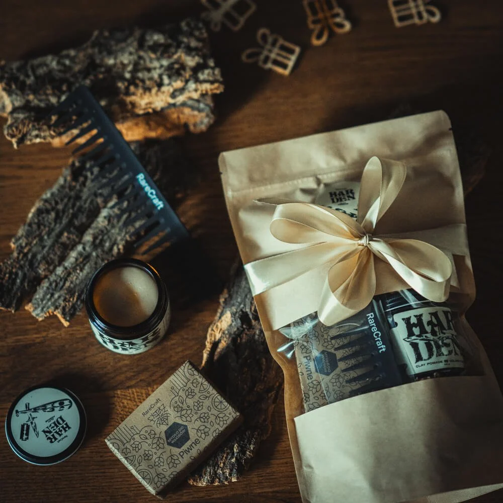 Zestaw-do-pielegnacji-brody-czarny-grzebien,-matowa-pomada,-mydlo-z-kwiatowym-wzorem,-zapakowane-w-papier-kraft-ze-wstazka,-ulozone-na-drewnianym-blacie-z-kawalkami-kory..jpg