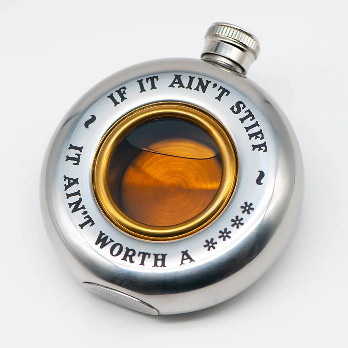 Okragla-stalowa-piersiowka-z-przezroczystym,-okraglym-oknem-i-zlota-ramka.-Widoczne-napisy-tekstem-IF-IT-AINT-STIFF-oraz-IT-AINT-WORTH-A-.-Piersiowka-ustawiona-na-bialym-tle,-w-pozycji-lezacej,-z-zamknieta-pokrywa..jpg
