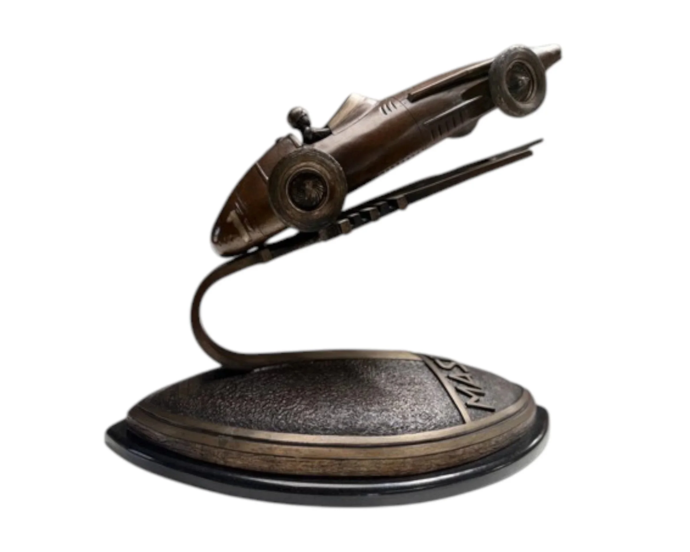 Bronze spaceship sculpture mounted on a round textured base.