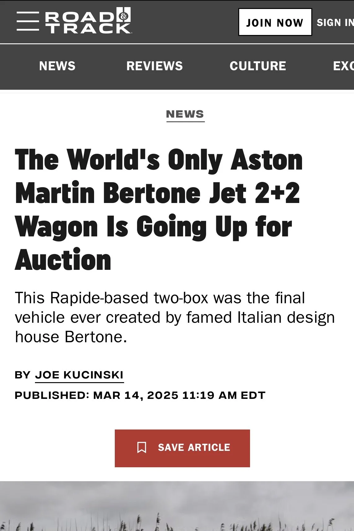 Screenshot of a news article from Road & Track website titled "The World's Only Aston Martin Bertone Jet 2+2 Wagon Is Going Up for Auction" by Joe Kucinski, published on March 14, 2025. The webpage has navigation links for News, Reviews, Culture, and Exhibits and a button to save the article. The background shows a landscape with tall, dry grass and a cloudy sky.