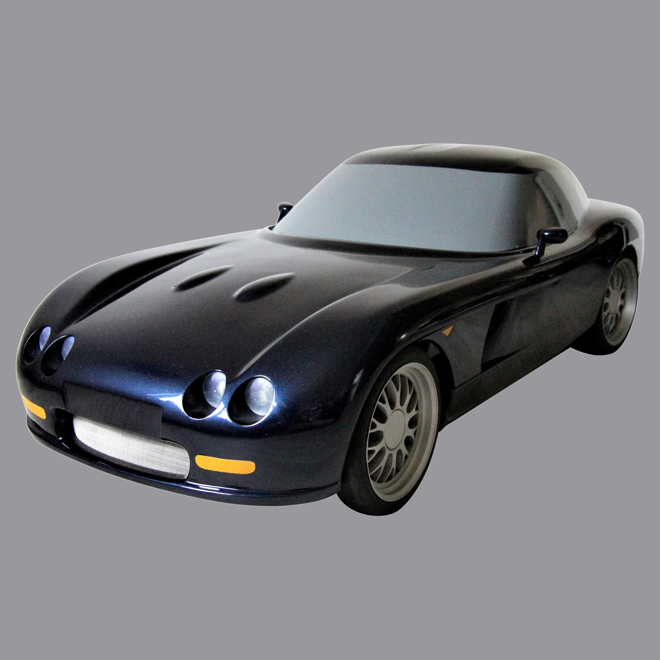 A black toy car resembling a classic sports car with a sleek, curved body and rounded headlights.