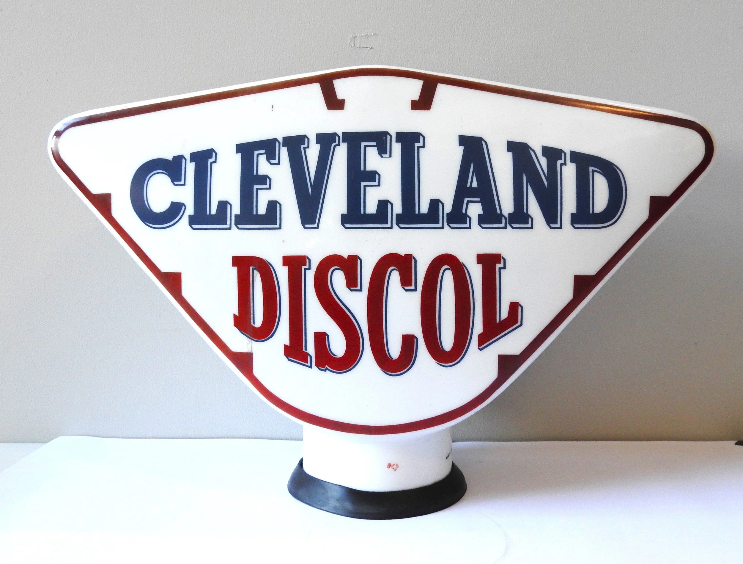 A vintage triangular neon sign reading 'Cleveland Disco' in blue and red letters.