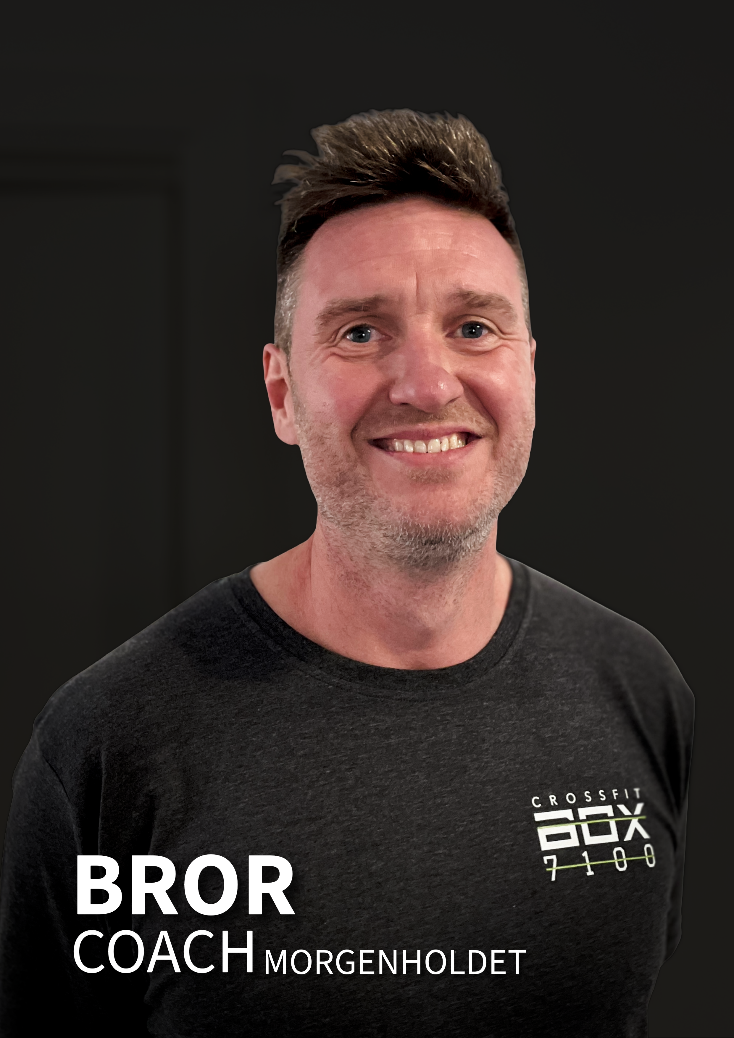 En mand med kort, op-stylet hår og skæg smiler foran en sort baggrund, iført en sort CrossFit T-shirt med teksten 'COACH MORGENHOLT'.