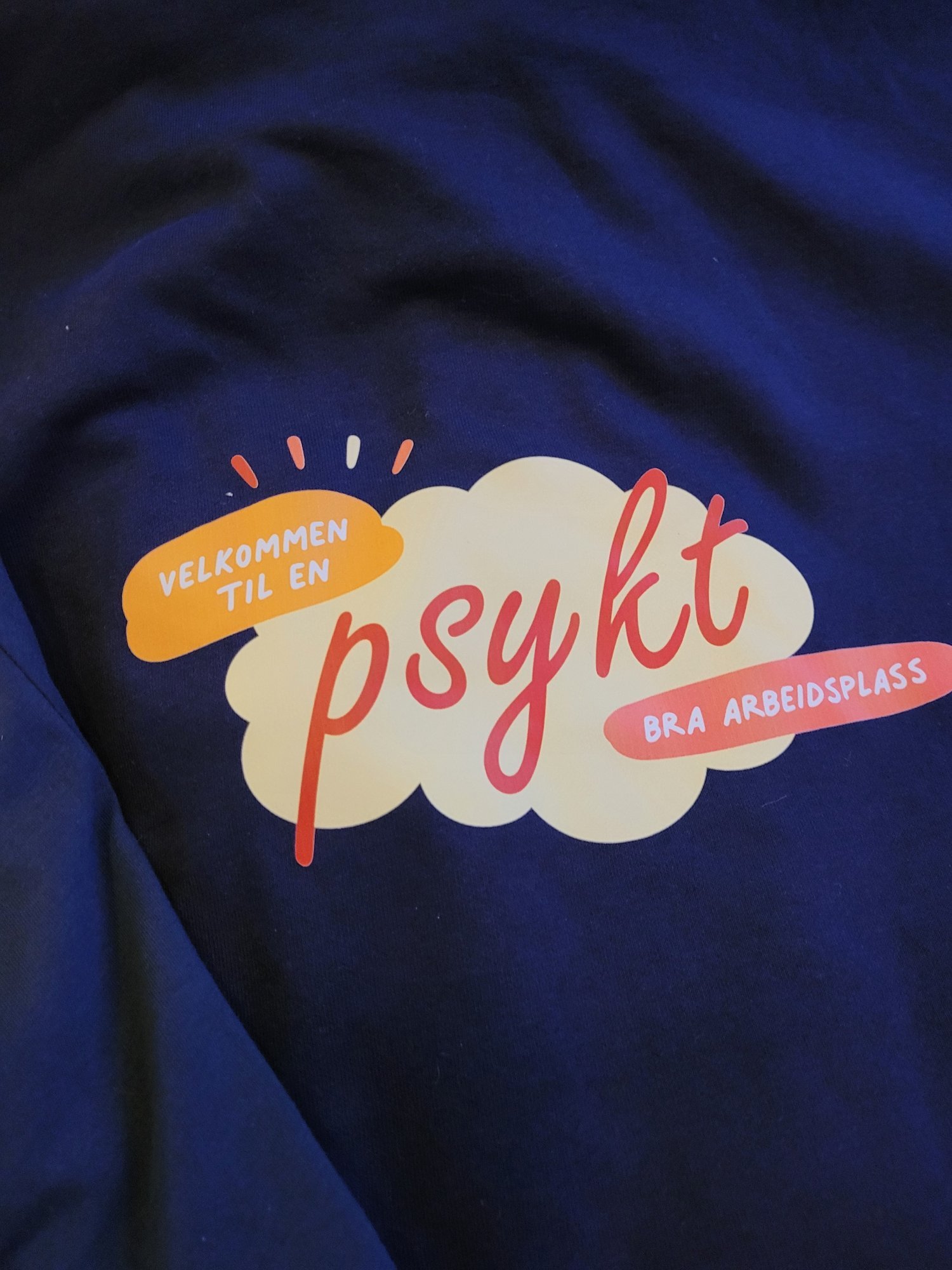 Tekst på mørk blå bakgrunn som sier "Velkommen til en psyk bra arbeidsplass" i lyse farger.