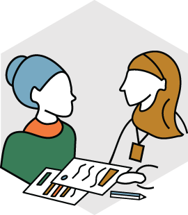 To kvinner som snakker med hverandre over et bord med papir og dokumenter.