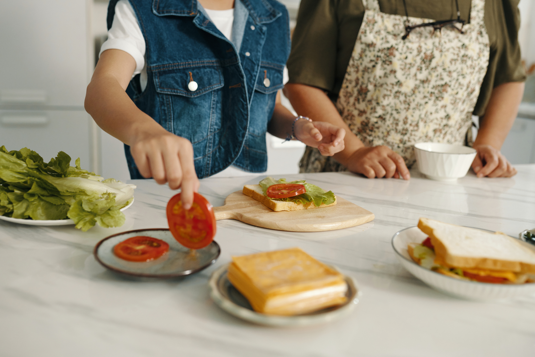 Support worker helping an NDIS participant prepare fresh, healthy sandwhiches for lunch