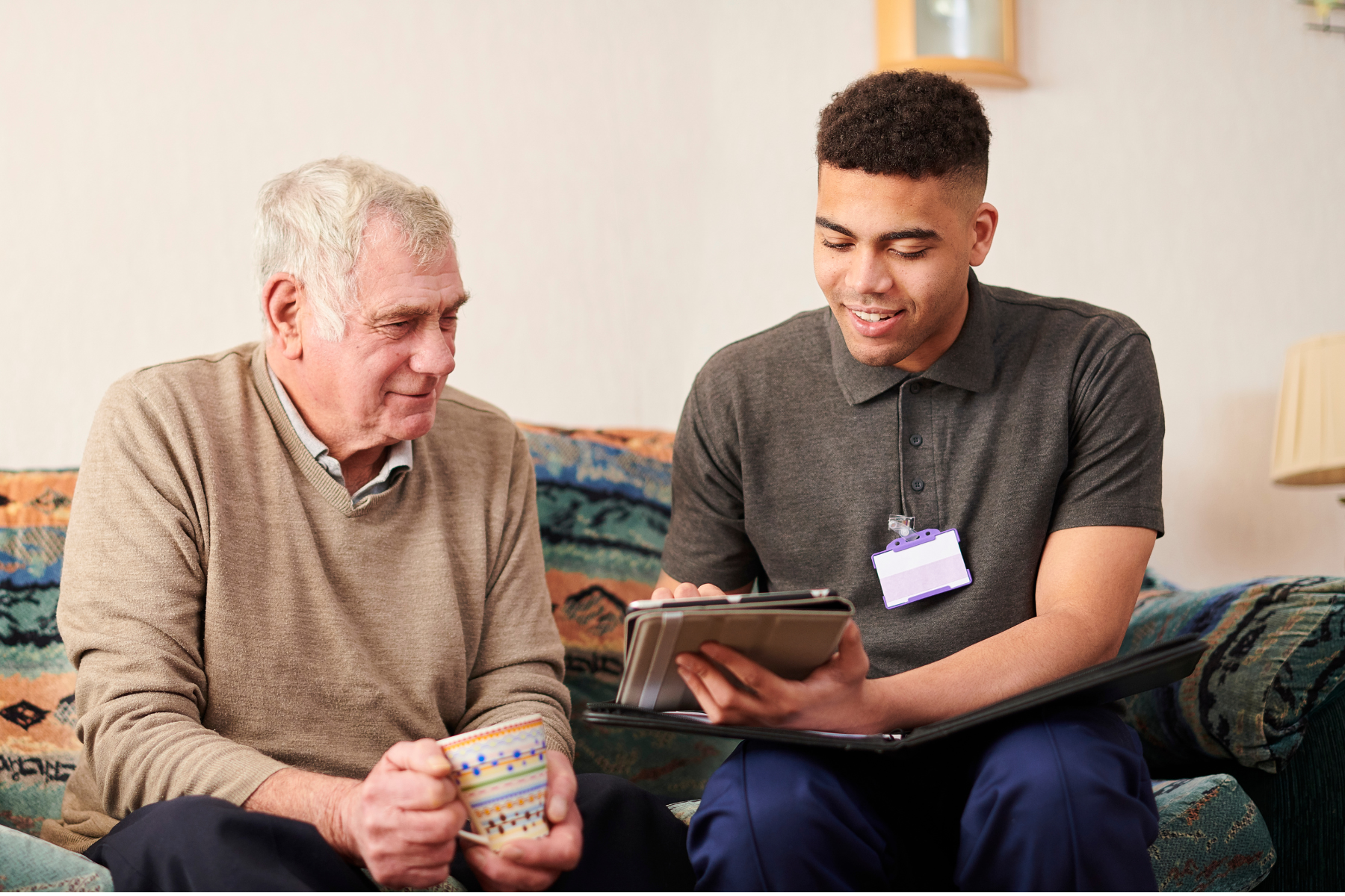 Young trainee completing modules whiile working with an elderly DVA funded man