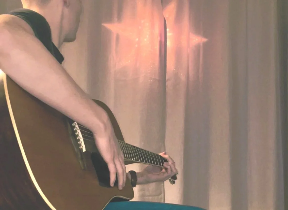 A person playing an acoustic guitar