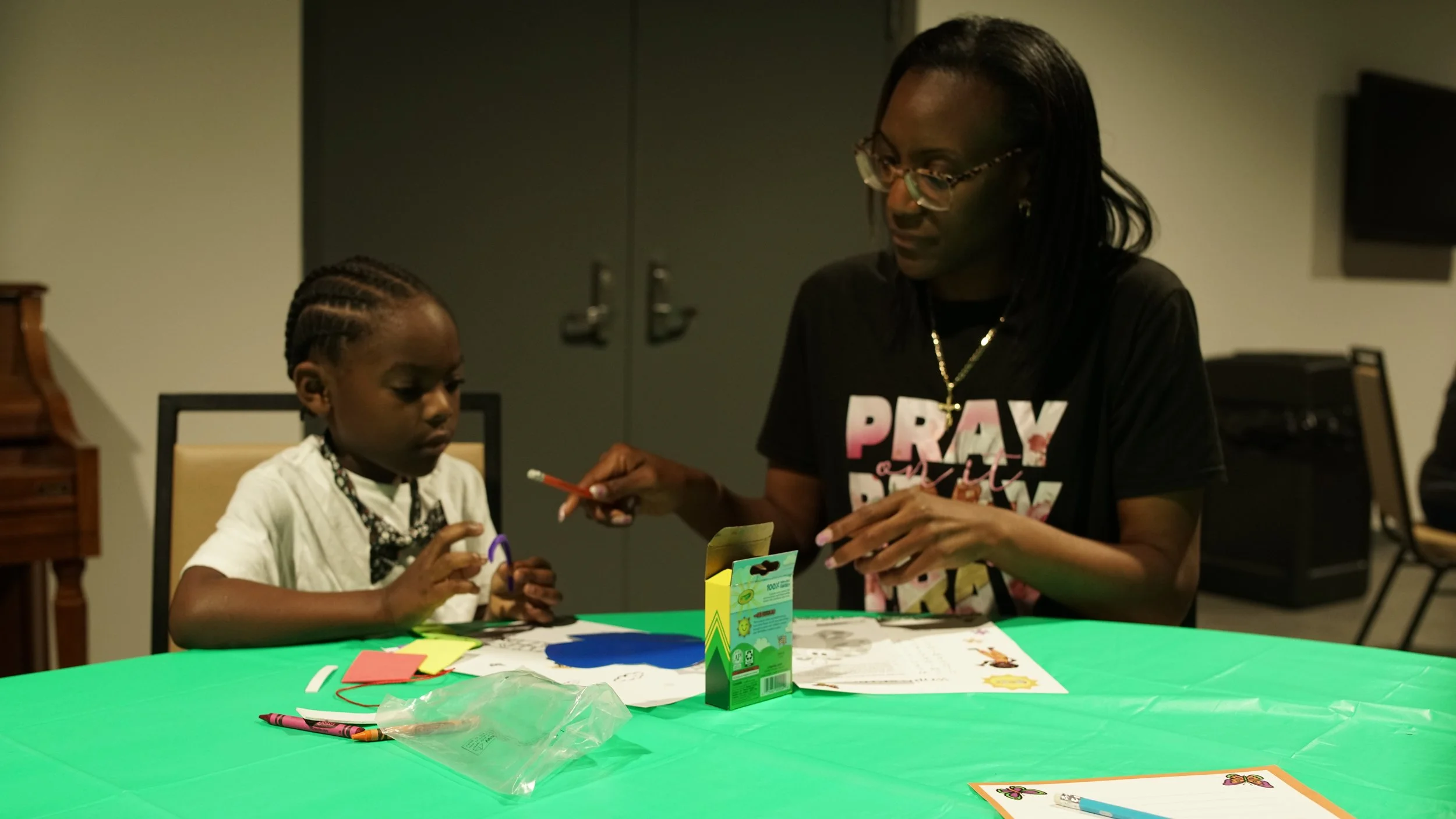 A child works with craft materials alongside an adult at It's Cool to Learn in Roanoke