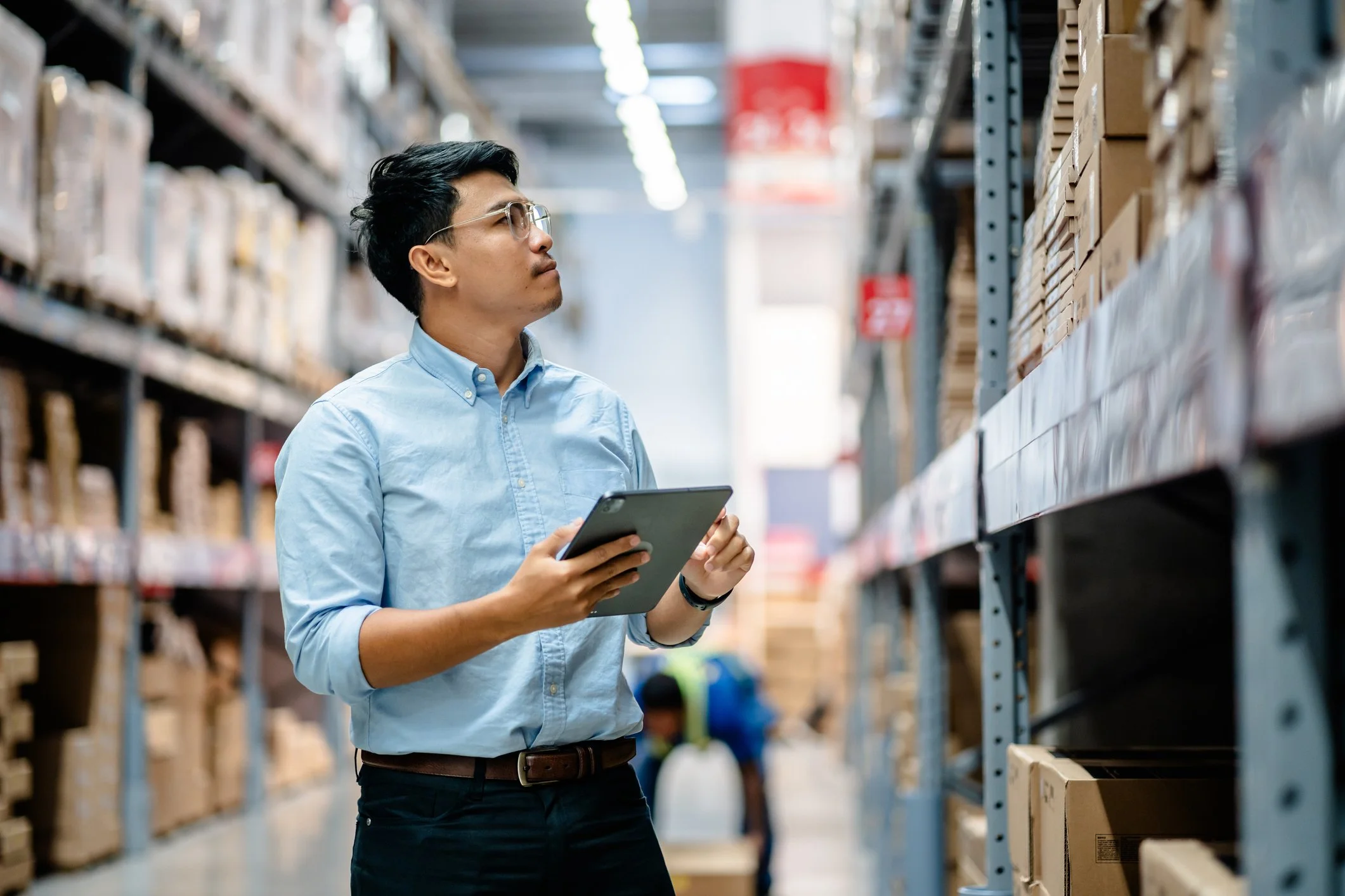 Auditor conducting a supplier qualification audit inside a warehouse, inspecting shelves stocked with medical device components.