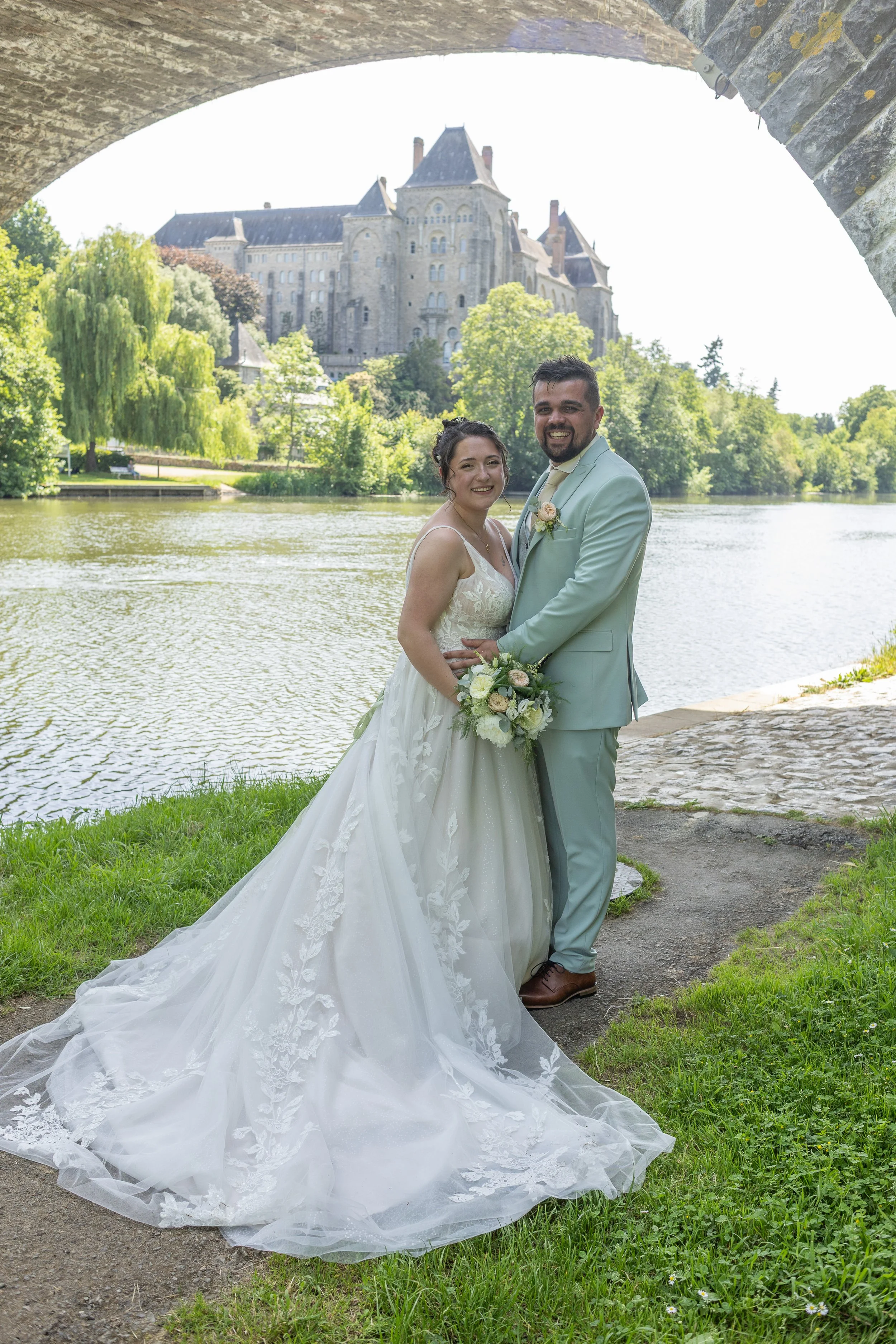 couple-mariés-enlacés-devant-abbaye-solesmes