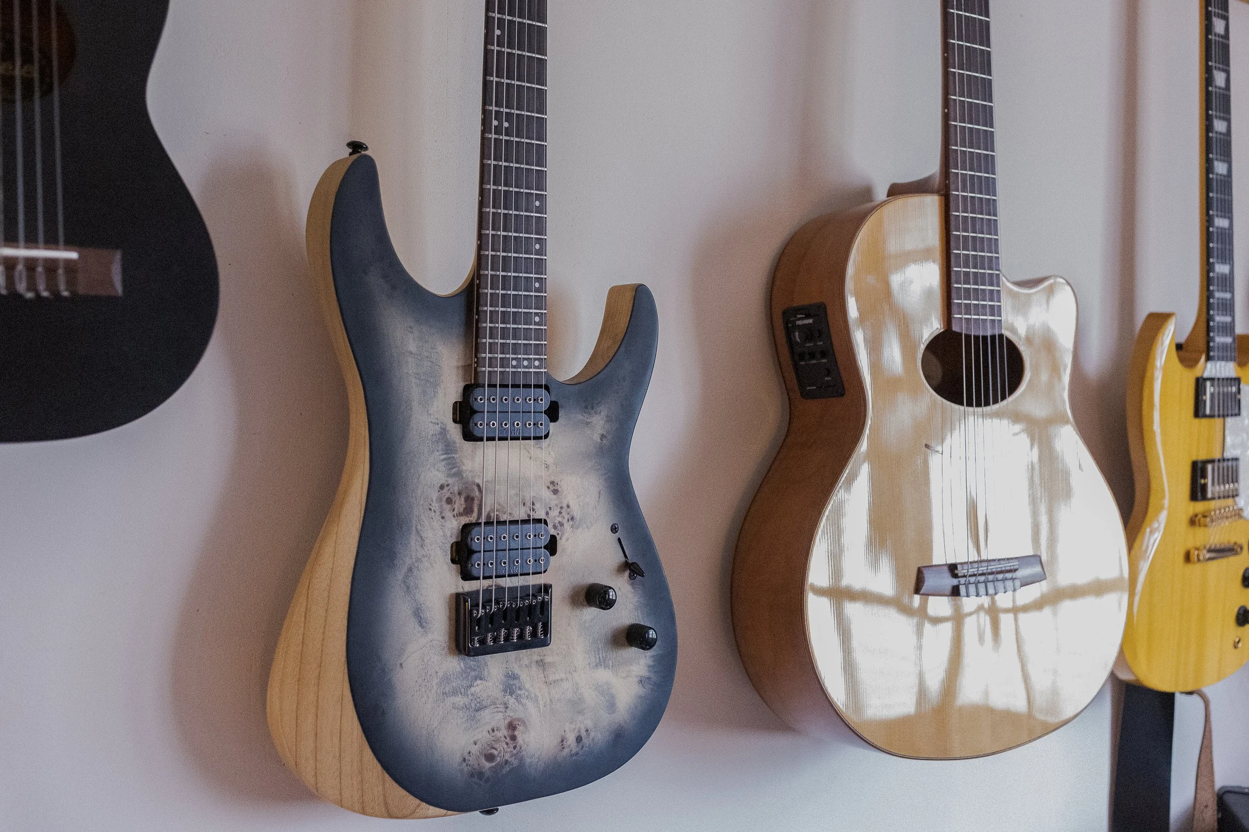 plusieurs guitares accrochées au mur pur cet ingénieur du son musicien. Portrait narratif Questions de curiosité