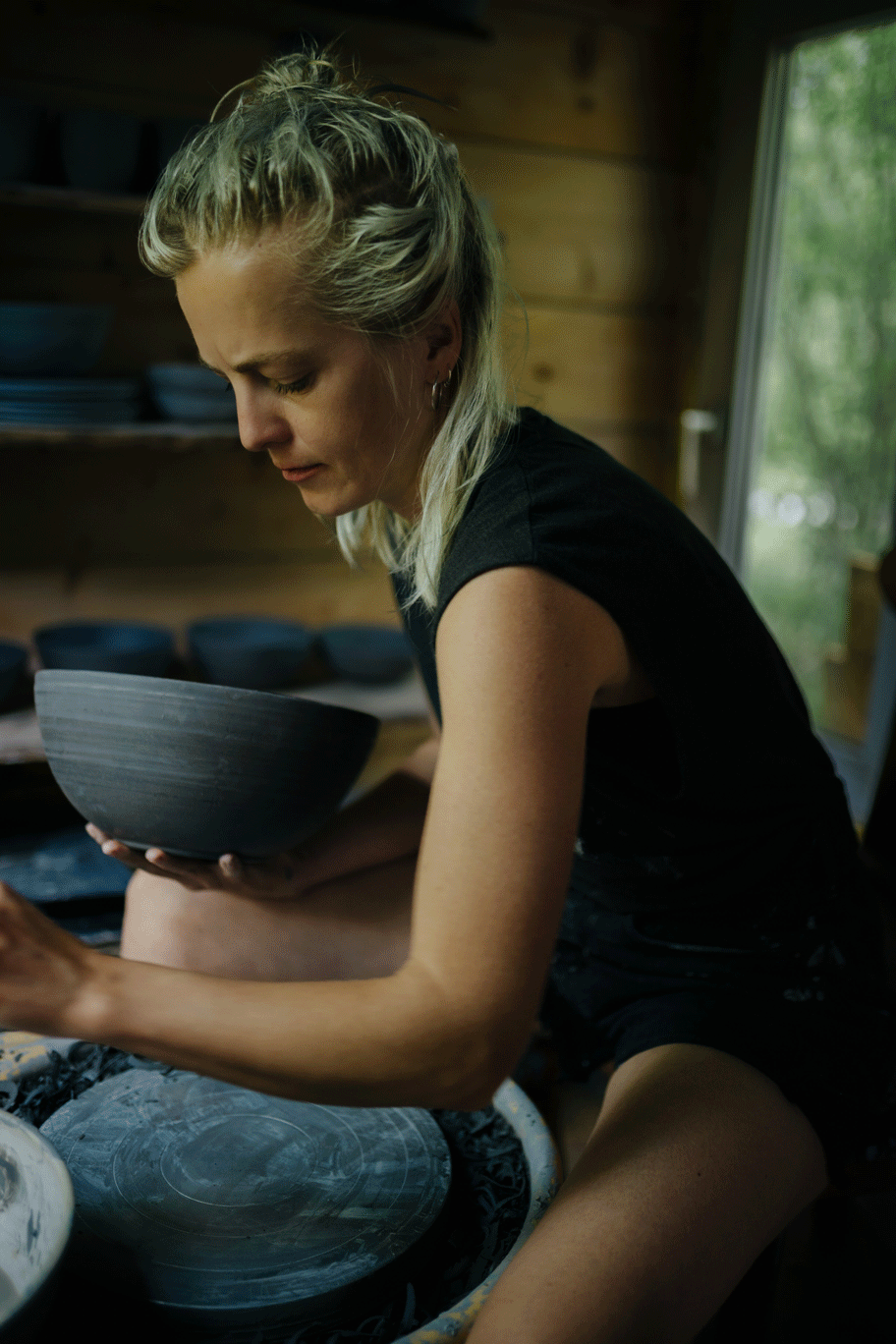 Camill formt eine Tonschale in ihrer Keramikwerkstatt in der freien Natur.