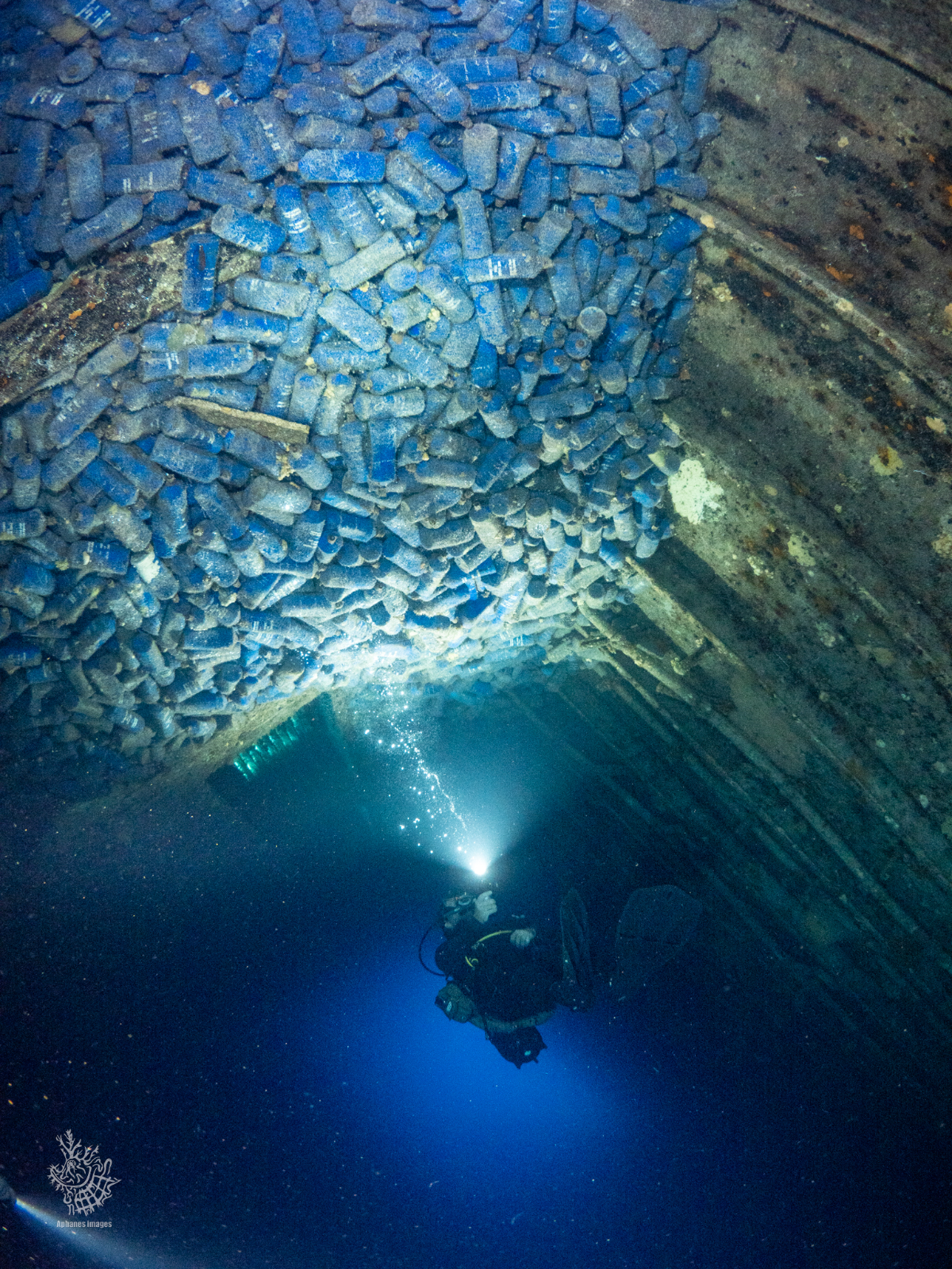 Scuba diver in a the Zenobia shipwreck with empty bottles.