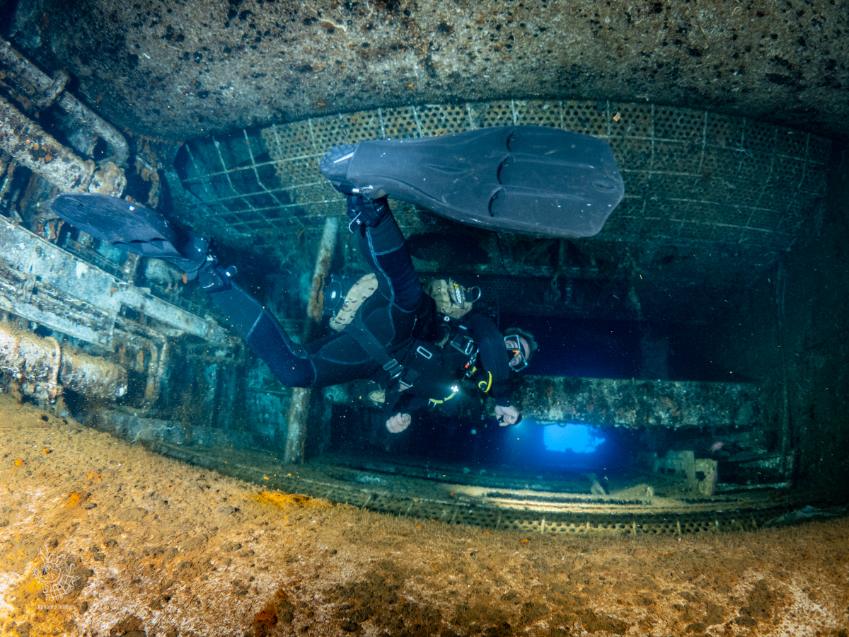 A scuba diver exploring the interior of the sunken shipwreck, Zenobia