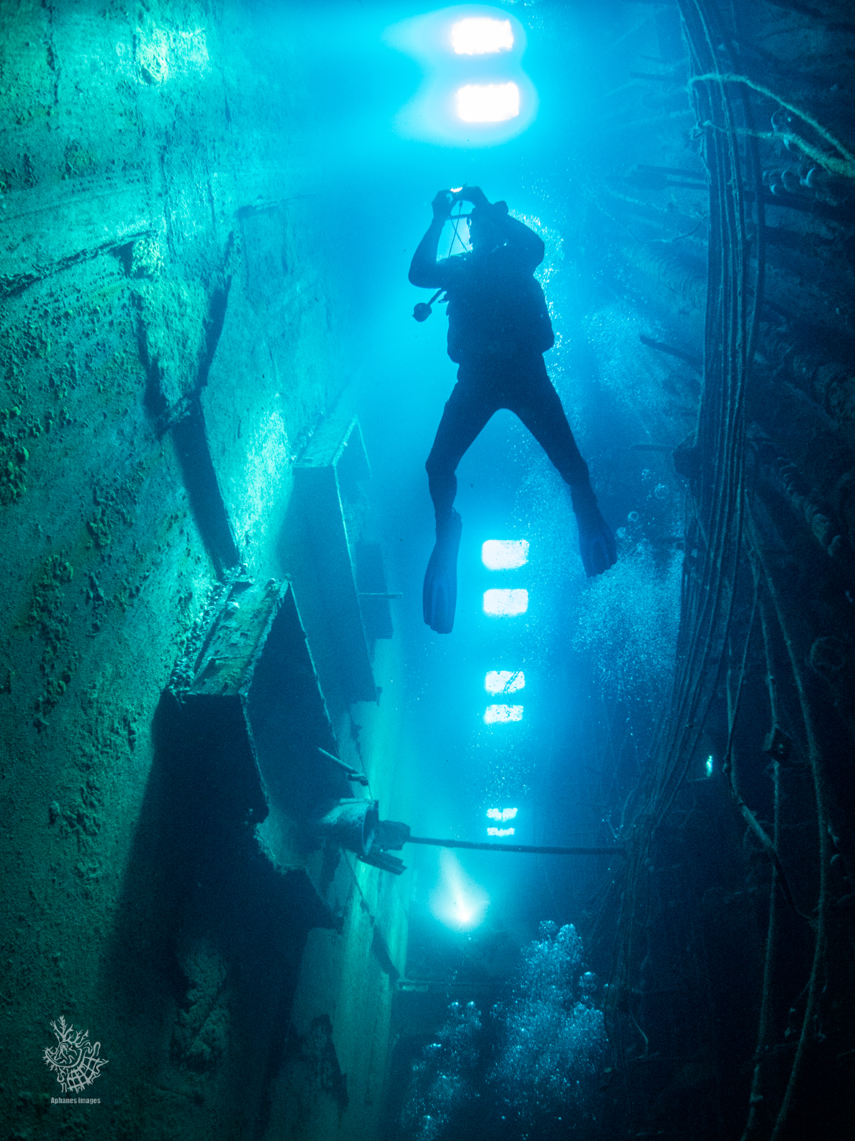 A scuba diver underwater exploring a sunken shipwreck, The Zenobia in Cyprus. 