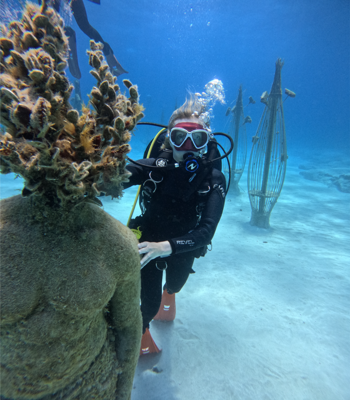 Scuba diver underwater examining a coral formation.