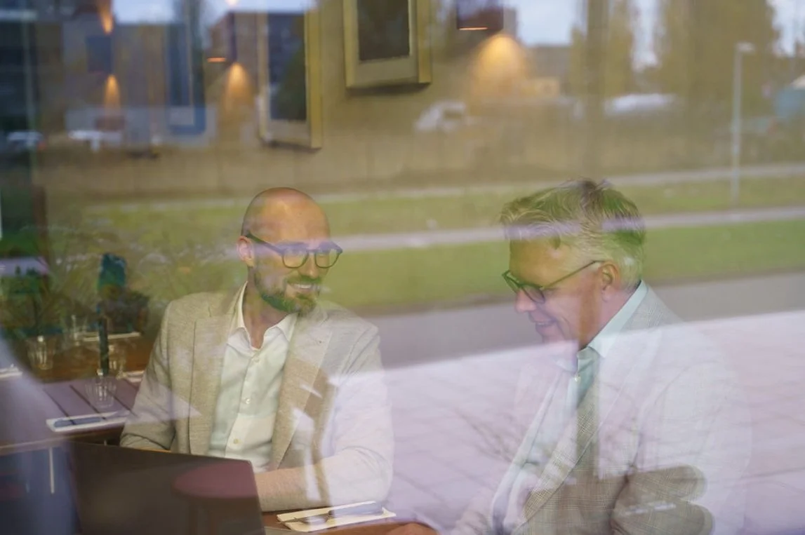 Jelmer and Martijn sitting at a table, having a conversation about their strategic plan.