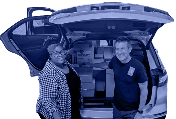 two people load a vehicle with boxes of medical supplies